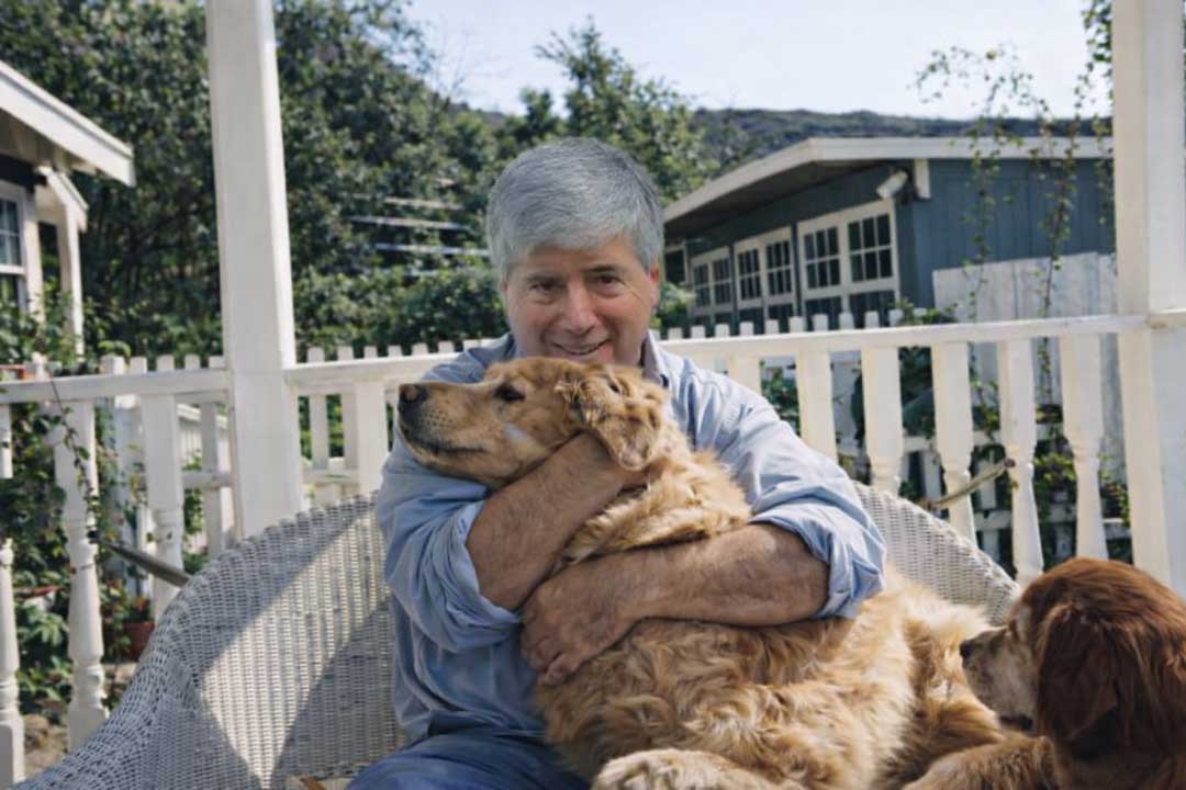 David Rosenfelt relaxing outdoors with his dogs in a warm, welcoming homepage portrait